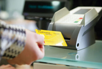 Bild einer Person welche die PostFinance-Karte in Richtung Zahlterminal hält